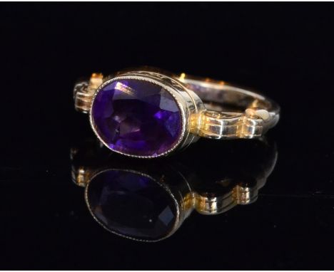 A 9ct hallmarked single stone amethyst ring, oval collar set stone flanked by scrolled shoulders, ring size N 1/2