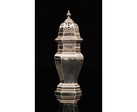 A George V hallmarked silver sugar castor of octagonal waisted form, the pierced cover with finial surmount above plain balus