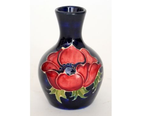 A small Moorcroft vase of globe and shaft form decorated in the Anemone pattern with crimson and purple flowers against a blu