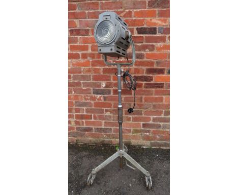 A VINTAGE KODAK FOCUSING STUDIO SPOTLIGHT ON ADJUSTABLE ROLLING STAND, the lamp having a steel casing and set on a telescopic