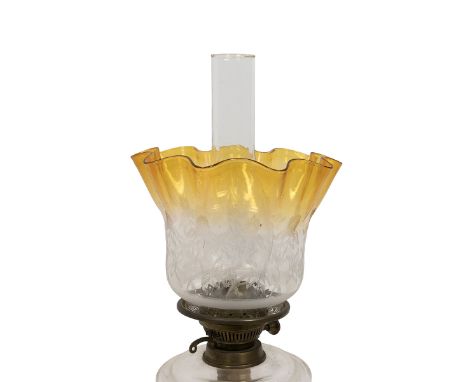 Turn of the century paraffin lamp with black glass socle base supporting a brass stem, a pressed clear glass reservoir, brass