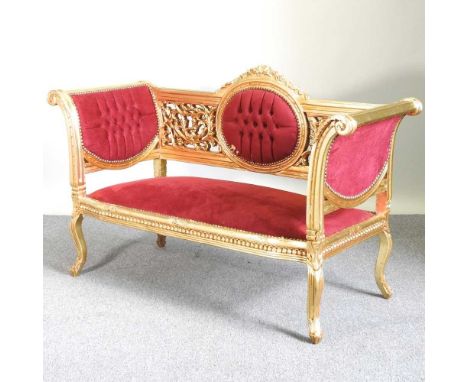 An ornate gilt framed sofa, upholstered in red, on cabriole legs156w x 63d x 97h cm