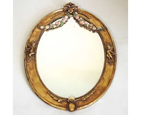 A continental gilt framed mirror, of oval shape, decorated with cherubs and swags, 65 x 97cm
