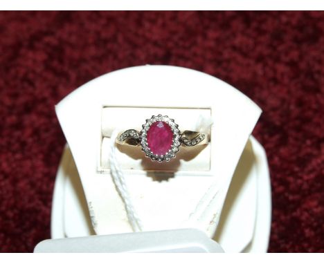 A ruby and diamond cluster ring, claw set an oval ruby within a surround of twenty 8/8 cut diamond points in 9ct gold mount, 