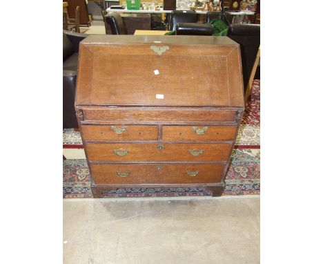 An antique oak bureau, the fall front with fitted interior above three graduated drawers on bracket feet, 91cm wide.