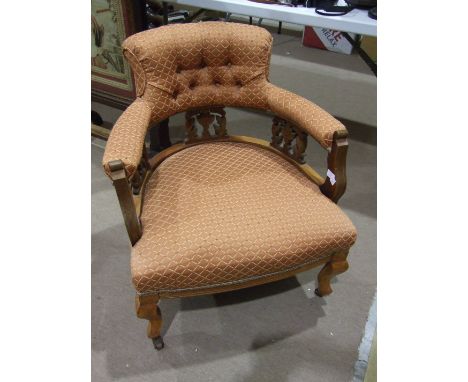 An Edwardian walnut frame tub-style chair with padded button back and arms, with upholstered seat, on shaped front legs.