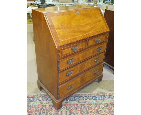 A reproduction walnut bureau, the fall front above two small and three long drawers, on bracket feet, 77.5cm wide.