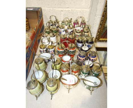 A collection of sixteen ceramic and glass cruets on metal stands, (16).