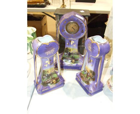 A black slate mantel timepiece, 26cm high and a three-piece ceramic clock set of Art Nouveau form decorated with rural scenes
