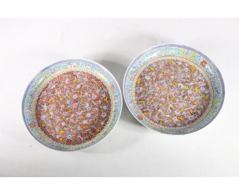 Pair of Chinese Famille Rose Millefleur shallow bowls, mid-20th century, the bowl decorated with polychrome flowers on a red 