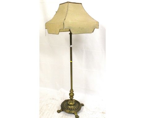Early 20th century free standing brass floor lamp, the turned column on reeded oval base and four paw feet, to top of fitting