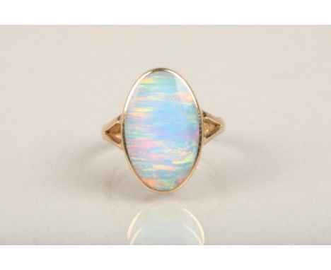 9ct gold and opal ring, the oval opal bezel set in gold frame leading to split shoulders on a plain band, opal size 1.9cm by 