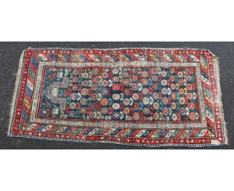 Kazak Shirvan prayer rug or runner, the repeating polychrome flower motifs on blue ground within striped border, 185cm x 86cm