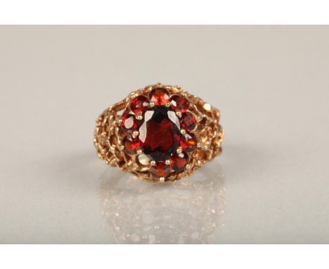 c1970s modernist 9ct gold and garnet cluster ring, the central and surrounding garnet cluster set on a textured openwork band