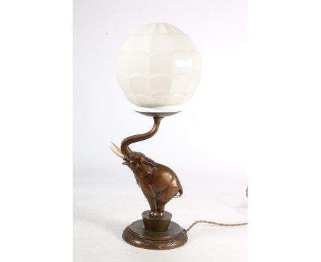 An Art Deco patinated spelter lamp base, c1930s, in the form of a circus elephant on stepped base supporting geometric glass 