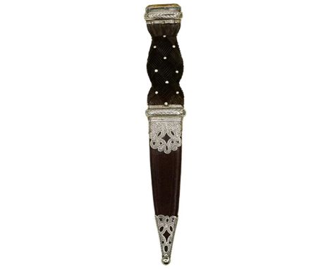 A SCOTTISH SGIAN DUBH, 8.75cm blade with faceted back edge, characteristic white metal mounted hilt, the pommel set with a st