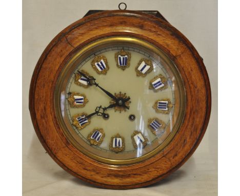 A French Wall Clock with glass dial and enamel numerals in a circular oak case, diameter of dial 9" (23cms) and a small Frenc