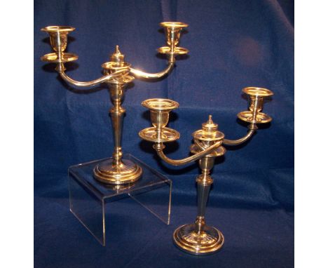 A pair of silver three branch Table Candelabra with scroll branches, reeded sconces and panel sided tapering stem on a circul