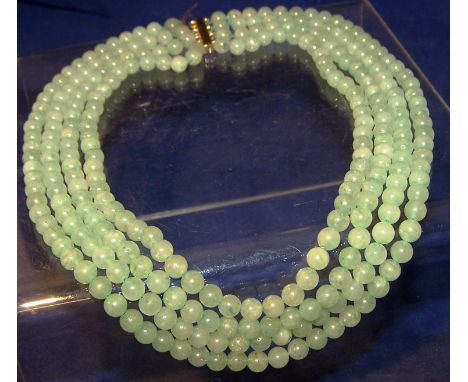 A four strand Jade Bead Necklace, the clasp testing as gold.