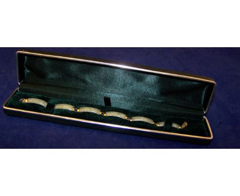 A Bracelet composed of six oblong jade panels with 9ct. gold mounts.