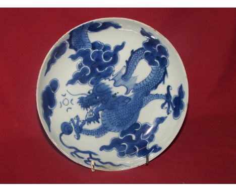 A Chinese blue and white Saucer Dish, painted with a dragon chasing a flaming pearl, Kangxi.  8" (20cms) diameter. (fritted r