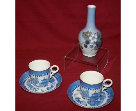 A pair of Royal Worcester Coffee Cups and Saucers decorated in blue and white, and a Royal Copenhagen Vase decorated with bla