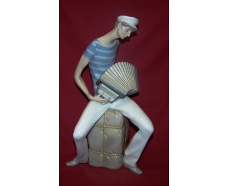 A Lladro Figure of an Accordion Player seated on a bale, designed by Salvador Furio (1970-1981), 13 1/2" (34cms) high.