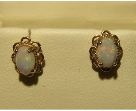 A pair of 9ct. gold Earrings each set with single oval opal.