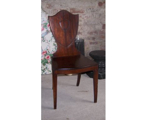 A Regency mahogany Hall Chair with shield shape back, serpentine fronted panel seat and square tapering supports.