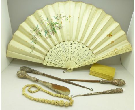 Four silver handled button hooks, an ivory fan, necklace, box, etc.