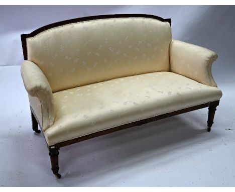 An Edwardian walnut framed sofa, with satin fabric cover, raised on turned front legs to ceramic castors, 150 cm l x 70 cm x 