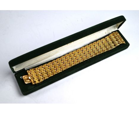 A yellow metal brick-link bracelet formed of alternating rows of engine turned and plain links, 3 cm wide, concealed snap, st