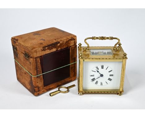 A rectangular lacqured brass cased carriage clock with white enamelled dial, 8 cm h o/all, in leather travel case and key