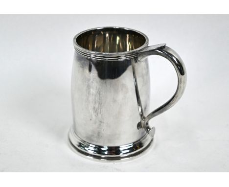 A heavy quality silver pint mug in the Arts and Crafts taste of rounded tapering cylindrical form with heart motif lower fini