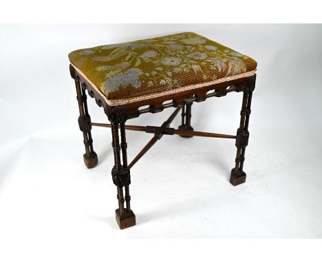 A 19th century Chippendale design mahogany stool, with overstuffed seat raised on cluster column legs with carved acanthus de