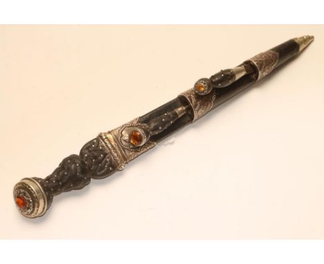 A SCOTTISH DIRK, 19th century, the fullered blade with serrated back edge, shaped wood grip studded and carved with Celtic de