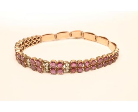 AN ART DECO RUBY AND DIAMOND BRACELET, claw set with twenty four graduated pairs of round facet cut rubies and three rows of 