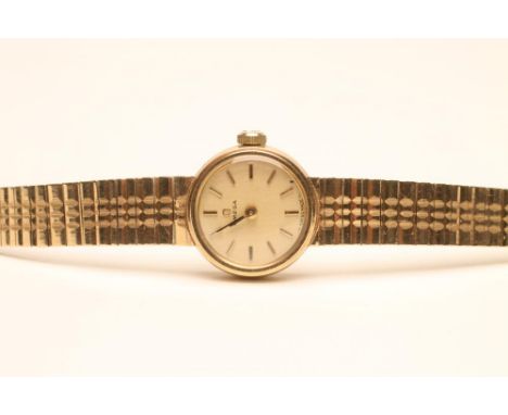 A LADY'S 9CT GOLD OMEGA WRISTWATCH, the matt gilt circular dial with applied gilt metal line batons, in a plain case on integ