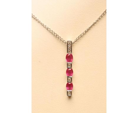 A RUBY AND DIAMOND LINE PENDANT, the 9ct white gold bar open back collet set with three diamonds and three bar-set rubies to 