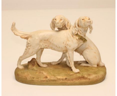 A ROYAL DUX BISQUE PORCELAIN MODEL, early 20th century, as a pair of setters, one seated, the other standing on a naturalisti