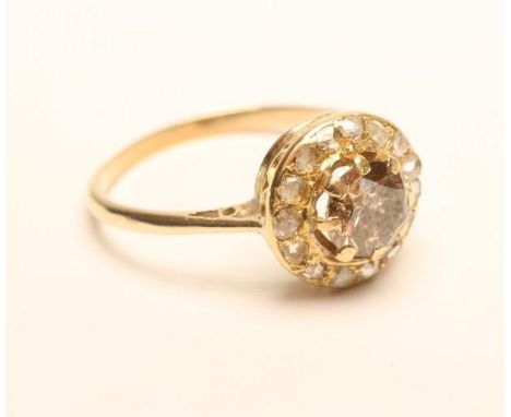 A VICTORIAN DIAMOND CLUSTER RING, the central brilliant cut cinnamon stone claw set to a border of fifteen rose cut white sto