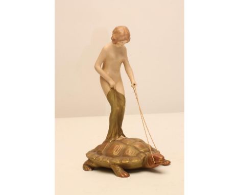 AN ART NOUVEAU ROYAL DUX BISQUE PORCELAIN FIGURE modelled as a naked maiden standing on the back of a tortoise, pink patch ma