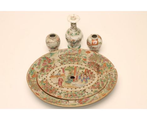 A CANTONESE PORCELAIN DISH AND DRAINER, late 18th century, of oval form, painted in famille rose enamels with figures at thei