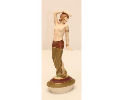 AN ART DECO ROYAL DUX BISQUE PORCELAIN FIGURE modelled as a semi nude young maiden wearing an Egyptianesque head-dress and to