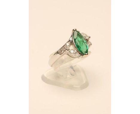 AN EMERALD AND DIAMOND RING, the oval facet cut Colombian emerald claw set to open shoulders each set with a marquise diamond