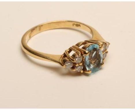 AN AQUAMARINE AND DIAMOND DRESS RING, the oval facet cut aquamarine claw set to triangular shoulders each set with three smal