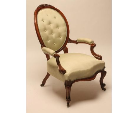 A VICTORIAN WALNUT FRAMED SALON CHAIR button upholstered in pale green watered silk, oval padded back with flower carved cres