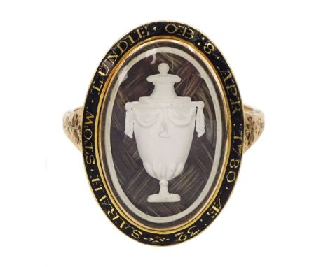 George III gold mourning ring, the bezel enclosing a lock of plaited hair under a reverse white painted urn glass panel, the 