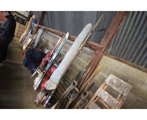 A garden parasol, branch loppers, gardening tools including rake, shovel, hoe etc