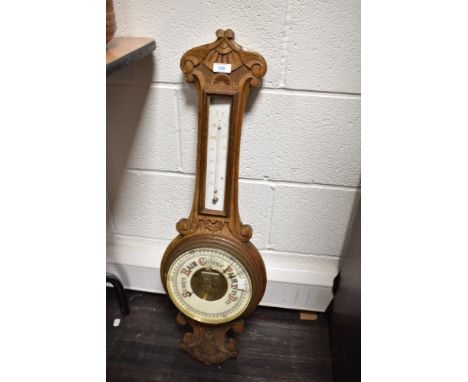 An early 20th century oak barometer having temperature gauge and carved floral decoration, h81cm